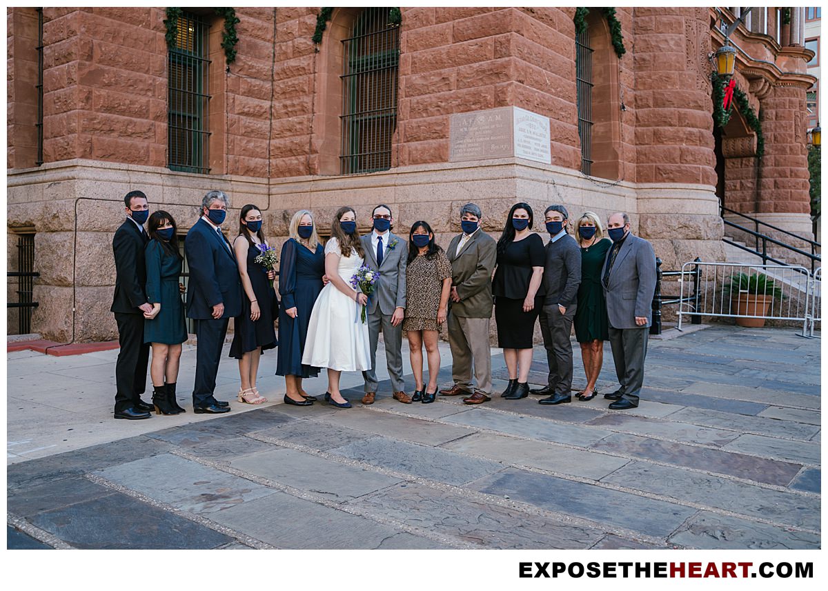 Bexar county courthouse wedding party posing wearing masks